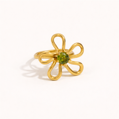 Gold wire-flower Vida RING set with a green stone center, shown at an angle on a cream backdrop.
