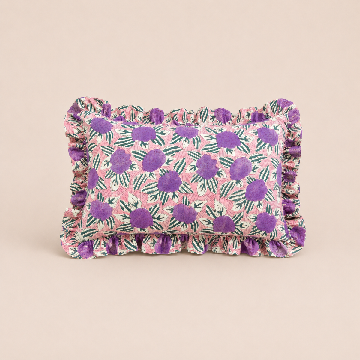 Violet Garden Rectangle cushion in pink with bold purple floral clusters and dark green leaves, finished with a ruffled edge.