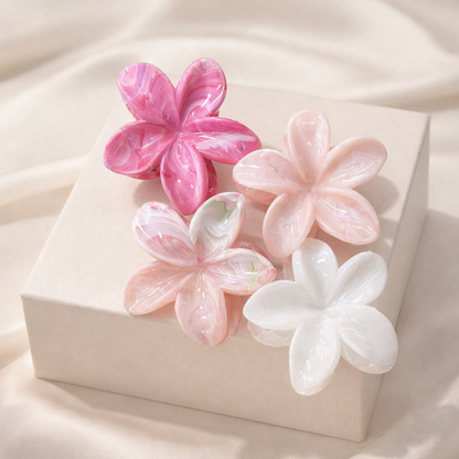 Virelle HAIR CLIP four flower-shaped acetate claw clips in magenta, blush pink, pink-green marble and white, styled on a gift box.