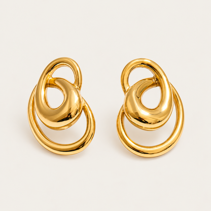 Pair of gold interlocking-ring stud earrings in a sculptural knot shape, product shot for the Folie à Trois Vortex EARRINGS.