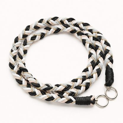 Black, white, and beige braided Voyage long phone cord with gold thread, coiled flat with silver rings.