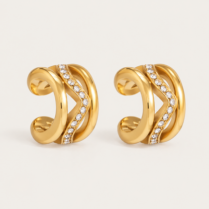 Pair of gold ear cuffs with layered wave bands and a diagonal row of pavé crystals, product shot for the Folie à Trois Wavelet EAR CUFF.