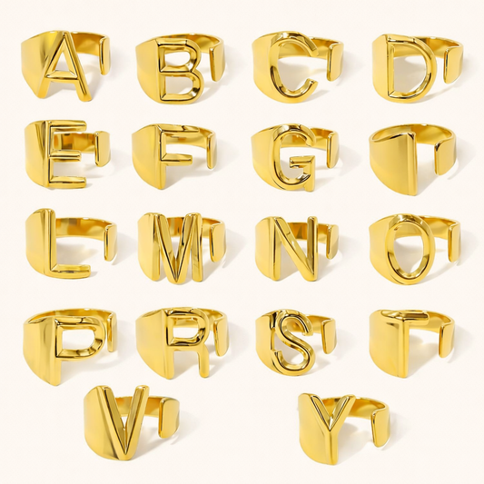 Full alphabet set of gold letter rings arranged in rows, each ring shaped as an open block letter — What Is Your Name RING.