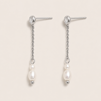 Silver drop earrings with a zirconia stud, fine chain and two freshwater pearls on a cream backdrop — Folie à Trois Whisper EARRINGS