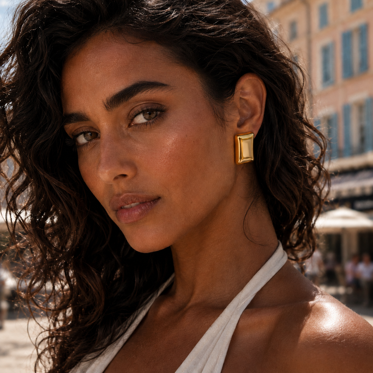 A model wears a chunky gold rectangular Who Told You EARRINGS stud with a polished, sculptural finish.