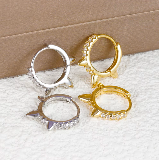 Wild Earrings pave spike huggie hoops in gold and silver tone, two matching pairs shown together closely.