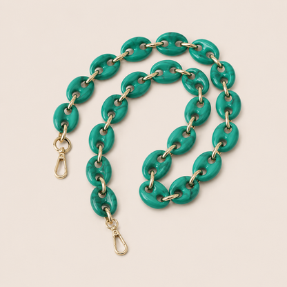 Folie à Trois Wilder long wholesale phone chain in teal green marbled puffed acetate links with gold connectors, coiled on a cream background.