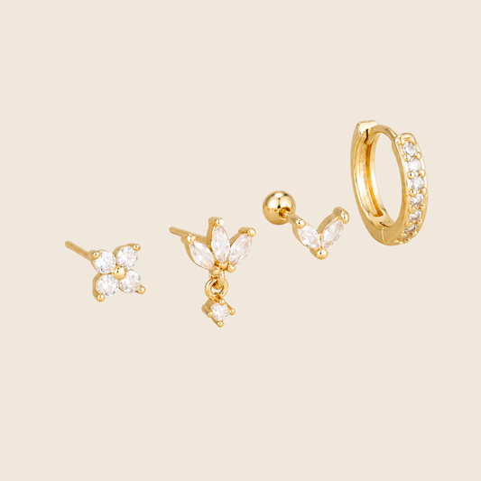 Four-piece Willow SET gold earrings: a four-stone flower stud, a marquise drop stud, a small marquise ear-climber, and a pave hoop.