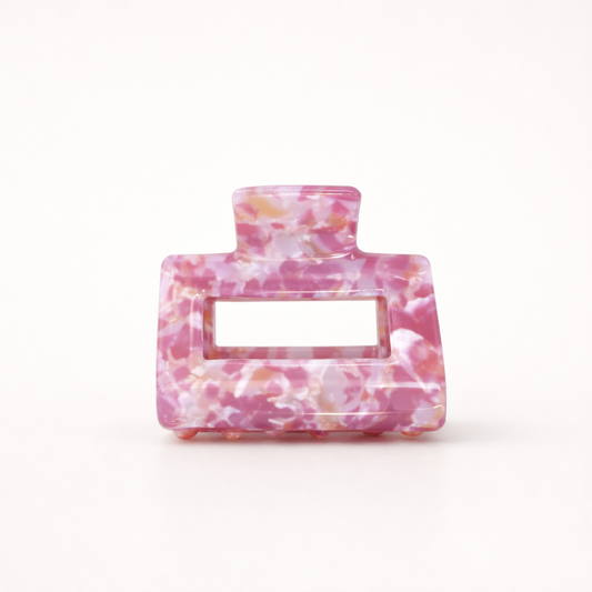 Wren HAIR CLIP rectangular acetate claw clip in a pink, white and gold speckled marble pattern, studio shot.