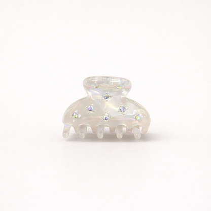 Yumi HAIR CLIP small acetate claw clip in iridescent white with crystal star accents, studio shot.