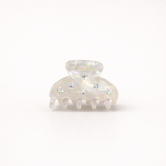 Yumi HAIR CLIP small acetate claw clip in iridescent white with crystal star accents, studio shot.