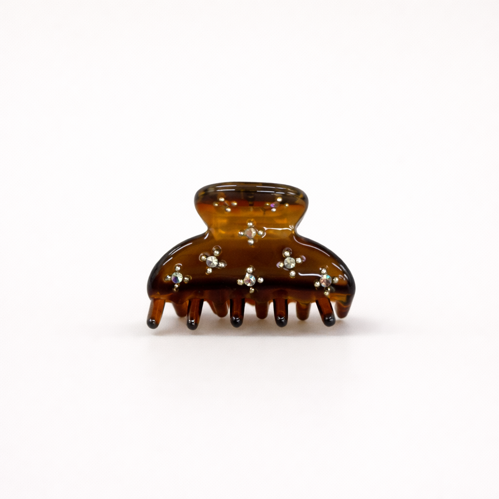 Yumi HAIR CLIP small acetate claw clip in amber tortoiseshell with crystal star accents, studio shot.
