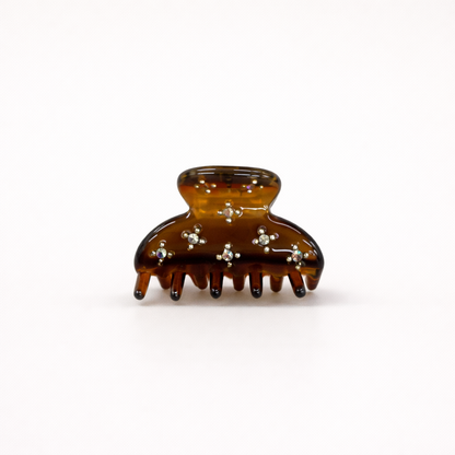 Yumi HAIR CLIP small acetate claw clip in amber tortoiseshell with crystal star accents, studio shot.