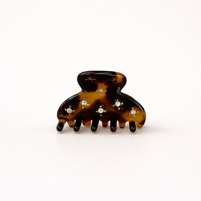 Yumi HAIR CLIP small acetate claw clip in dark tortoiseshell with crystal star accents, studio shot.