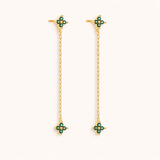 Zabbarra Earrings in gold with emerald-green crystals, a long chain drop connecting two matching clover-crystal stations.