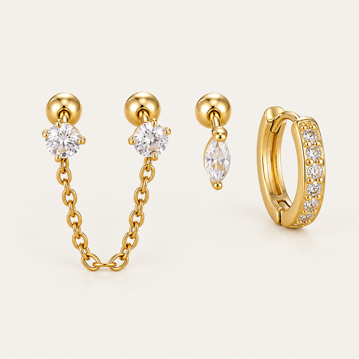 Three gold Folie à Trois Zélie SET pieces: a chain-linked double stud, a marquise drop stud and a pavé huggie hoop.