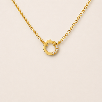 The Zircon Charm NECKLACE worn at the neckline, a gold chain with a pave zircon circle connector and no charms attached.