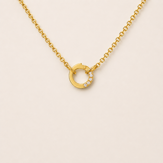 The Zircon Charm NECKLACE worn at the neckline, a gold chain with a pave zircon circle connector and no charms attached.