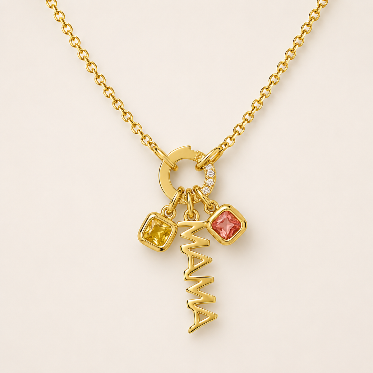 The Zircon Charm NECKLACE in close-up, a pave zircon circle connector holding a gold MAMA script charm and two square gems.