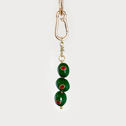 Livia BAG CHARM - green enamel olive charm with red rhinestones on a gold-tone lobster clasp