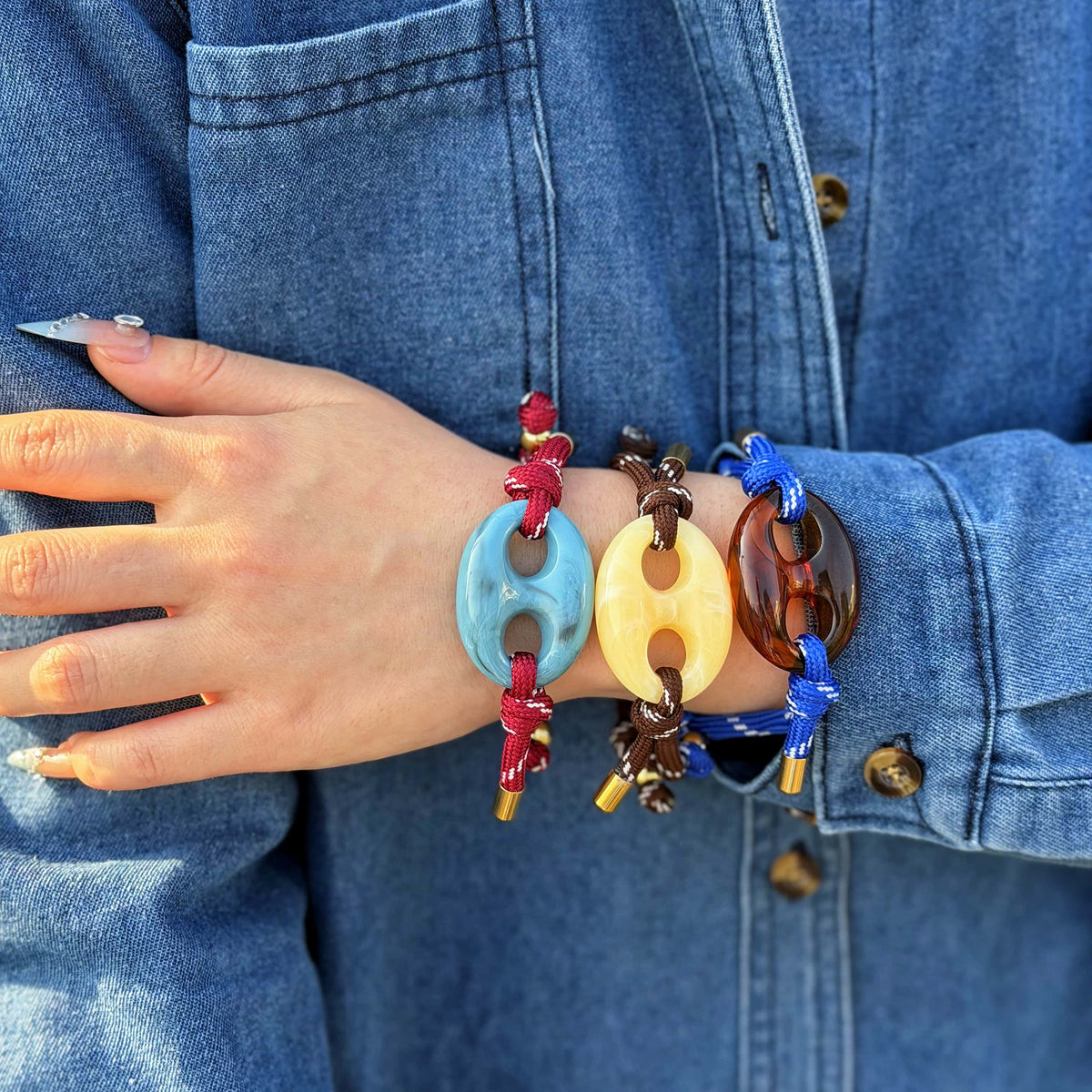 Pecan Pig Nose BRACELET - stack of three colorful rope bracelets worn on the wrist with denim