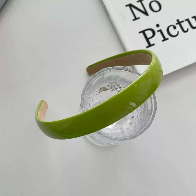 Yellow-green patent headband styled on a glass tumbler, from a generic headband catalog set.