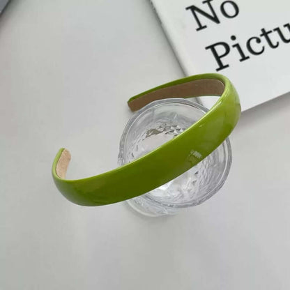 Yellow-green patent headband styled on a glass tumbler, from a generic headband catalog set.
