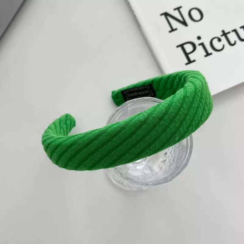 Bright green cable-knit padded headband styled on a glass tumbler, from a generic headband catalog set.