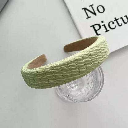 Pale green woven-texture padded headband styled on a glass tumbler, from a generic headband catalog set.