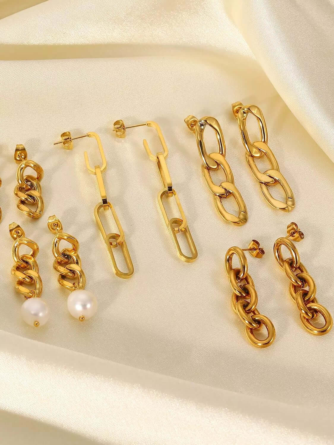 On cream satin, Lotte Earrings display their range of gold chain-link styles from delicate to chunky.