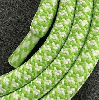 Extreme close-up of the green and white woven texture of a Multi Colorful PHONE CORD on gray fabric.