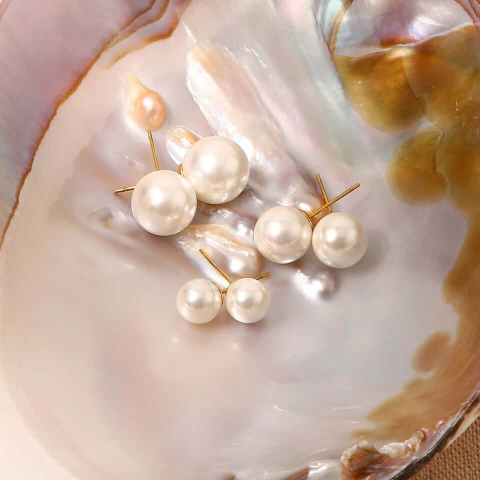 Nestled in an open oyster shell, Pearl Me Earrings display their pearl studs in three graduated sizes.