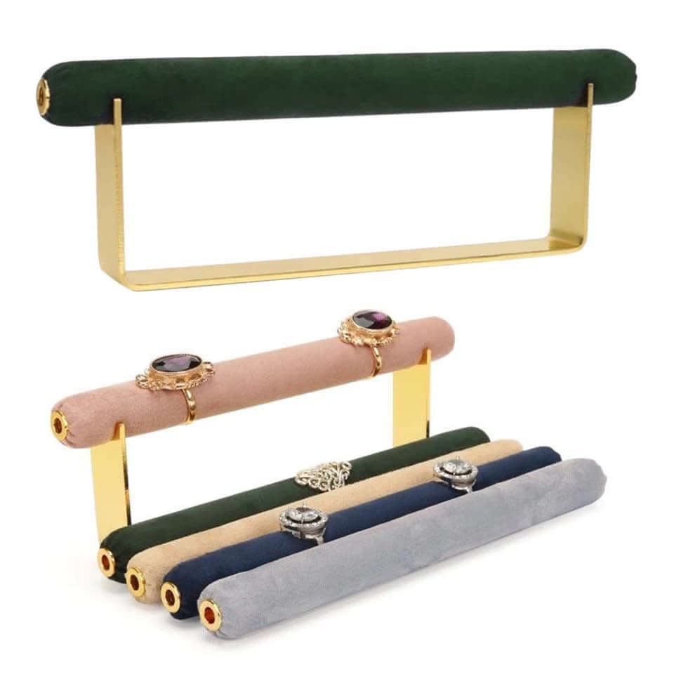 Velvet Ring DISPLAY stands in gold, an empty green bar shown above a tiered set of mauve, green, tan, navy, and grey bars holding rings.